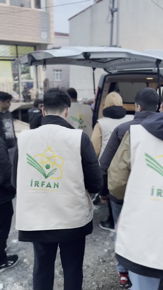 متطوعو فريق حفظ النعمة بسترات عرفان عند باص التوزيع